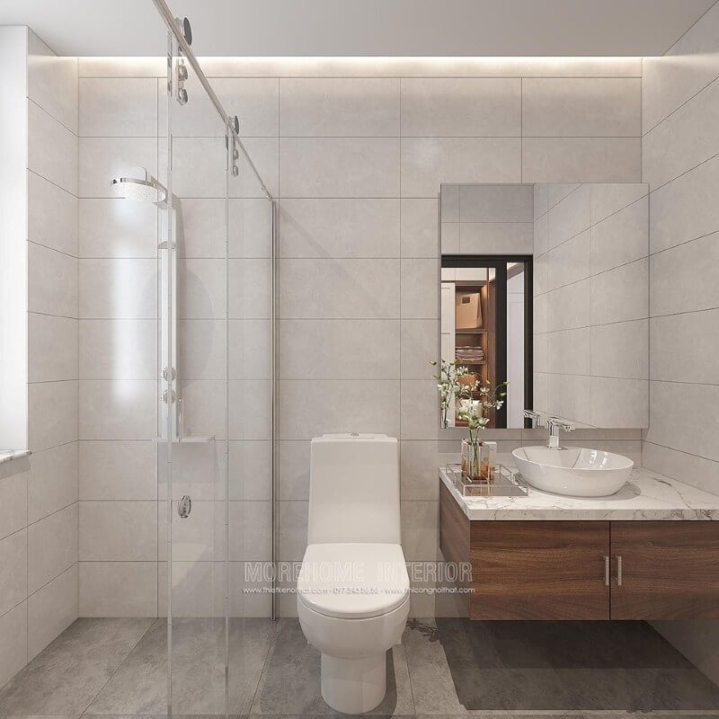 Thiết kế phòng tắm chung cư theo phong cách hiện đại đẹp với cách lựa chọn đồ vật tinh gọn nhưng lại tạo vẻ đẹp sang trọng cuốn hút từ tường ốp gạch giả bê tông, gương trang trí không khung ốp tường, phòng tắm kính cửa trượt.